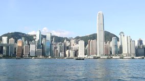 Hong Kong skyline at sunrise in morning.  View of Kowloon pier, avenue of stars in Tsim Sha Tsui.  Victoria Harbour, Central, Causeway Bay cityscape. Passenger cargo ship traffic transport. Video clip