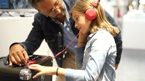 Father and daughter checking music in multimedia store