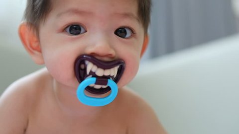 asian kid baby sucking nipple pacifier fancy vampire teeth dracula monster in halloween celebration party