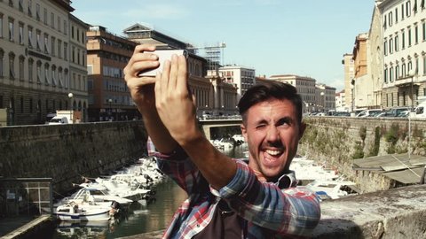 Making selfie, young man taking a selfie making crazy face 