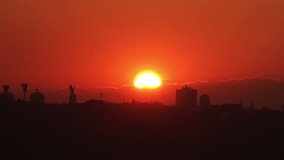 Timelapse of Huge Full Red Sun going to Sunset above the City. 4K Ultra HD 3840x2160 Video Clip