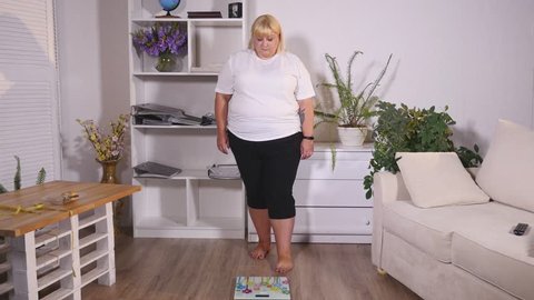 fat woman stands on the scales