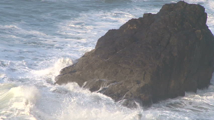 Pacific Ocean heavy, strong waves breaking with sound at high tide on rocky