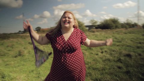 A fat village girl dances on a field. HD