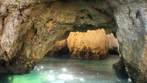 Boat expedition Into A Secret Sea Cave. POV scene of boat floating into the ocean passing inside a rock cave