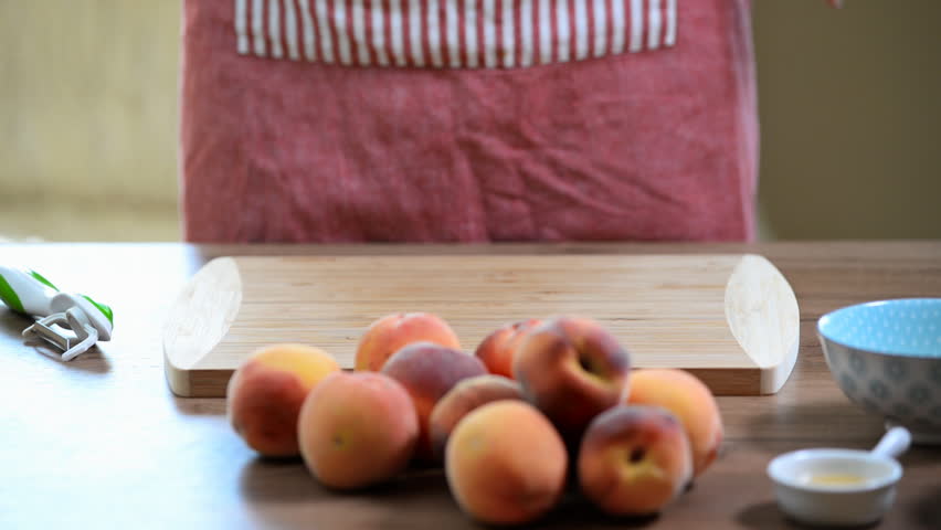 female hands peeling a blanched peach
