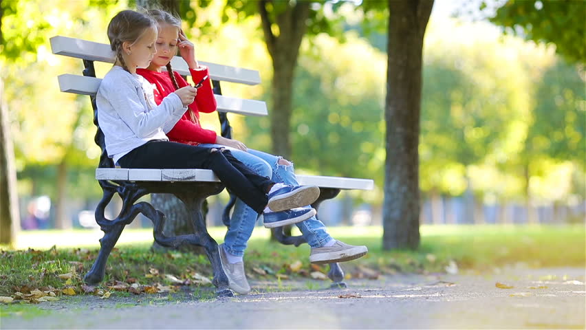 Little adorable girls at warm sunny autumn day outdoors