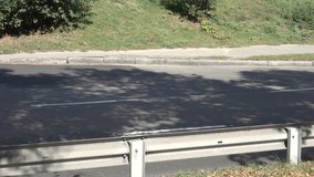 Small plot of asphalt road with cars passing by it