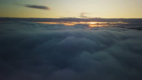 Epic flying above clouds at sunrise. Aerial slow motion flight with golden morning colors
