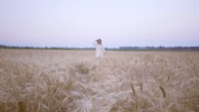 Blur view of young happy woman in white dress running in the field and waving her hat
