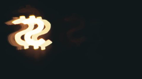 Dollar sign shaped bokeh of car lights at night.
