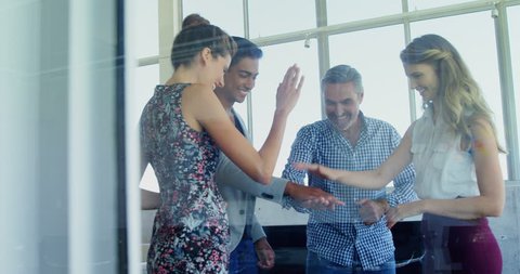 Group of smiling executives forming hand stack in office 4k