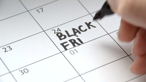 Writing BLACK FRIDAY on calendar with a black marker