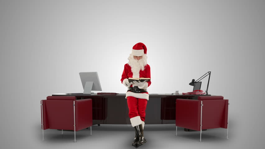 Santa Claus reading a book in his modern Christmas Office, against white