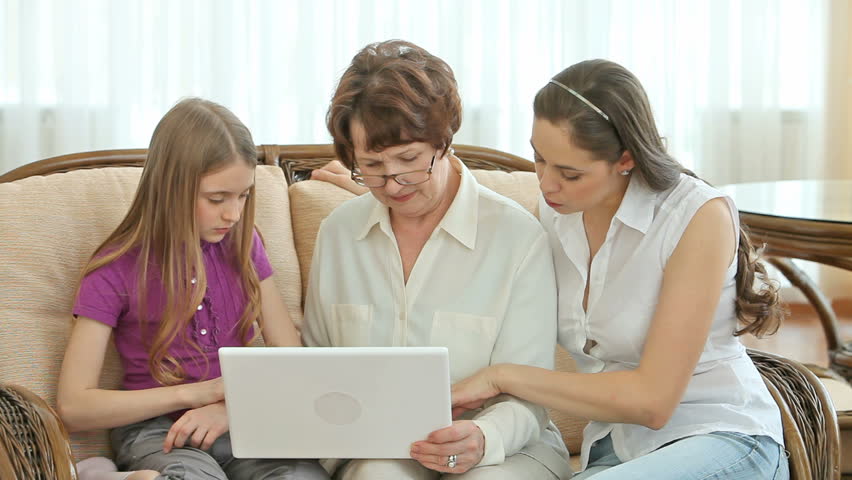 Charming senior lady using laptop with the help of her granddaughters | Shutterstock HD Video #3123325