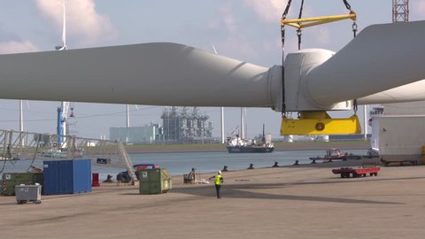 EEMSHAVEN, THE NETHERLANDS - SEPTEMBER 2017: hoisting wind turbine rotor blades on board an offshore construction vessel.
