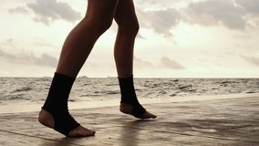 High pace video: Female boxer's legs moving on during the training. Woman is training by the beach. Closeup on legs