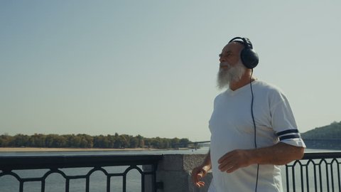 Sporty old man runs near the river स्टॉक व्हिडिओ