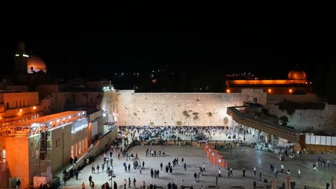 Timelapse of the western wall - the prayer plaza at midnight filled with religious Jewish people praying 