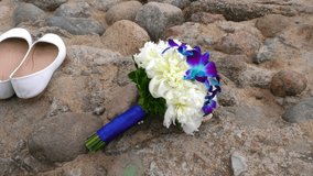 The bride's bouquet and white shoes abandoned on the beach. Conceptual videos of Boulders beach and wedding details.