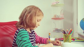 Video of pretty little girl drawing with colorful pencils
