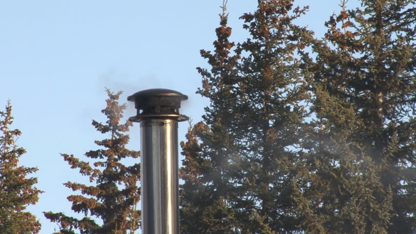 A stovepipe chimney exhausts wood smoke from a wood-burning stove into the air.