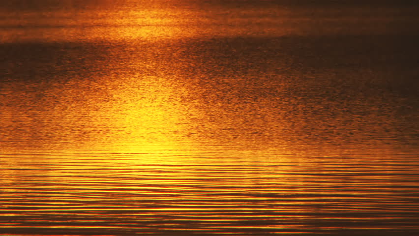 Resplendent sunset reflected off a lake's varied and soothingly patterned