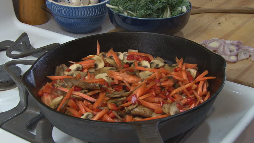Preparing food - seasoning cooking vegetables with crushed herbs.