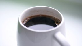 Hot black coffee with the steam in a white mug, morning beverage, video HD 1080