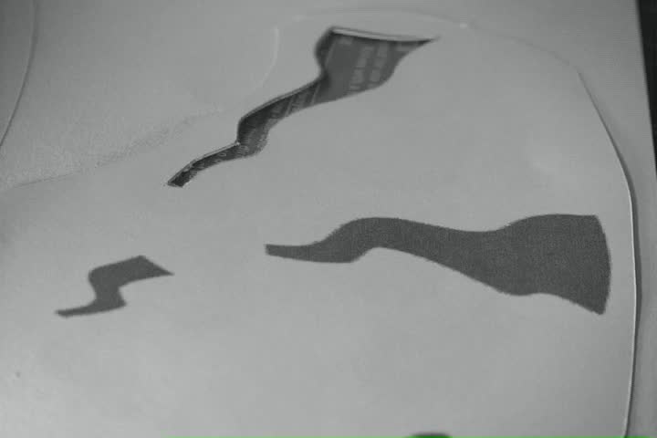 A stencil being cut by a razor.