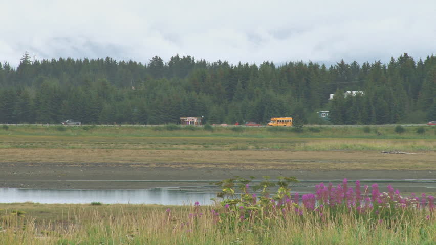 school bus making its way across the slough road dam