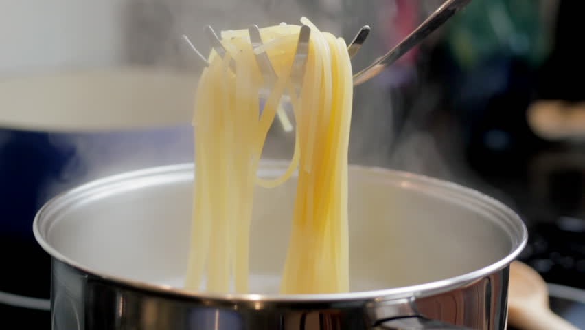 Taking spaghetti from saucepan