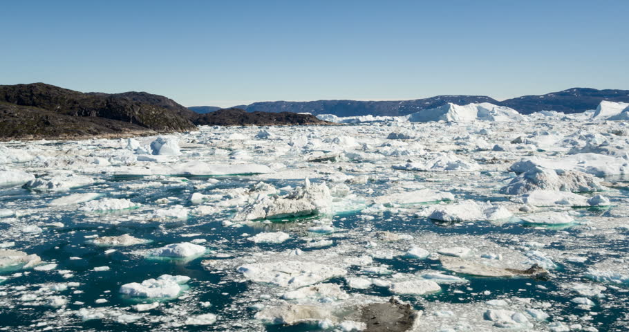 Ice and Icebergs in Icefjord - aerial video of arctic iceberg nature landscape on Greenland. Iceberg and ice in fjord from melting glacier. Ilulissat icefjord, Disko bay, Greenland. Climate change.