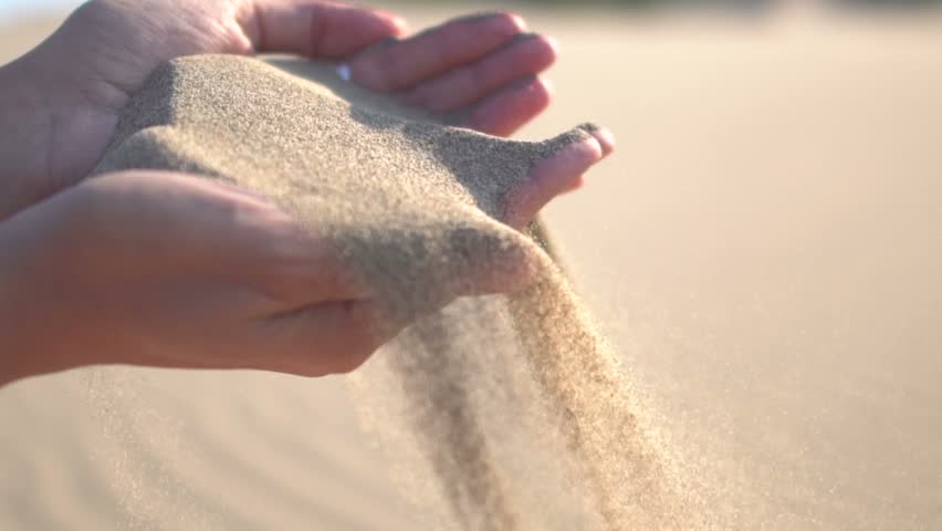 Close up of woman pouring sand running through fingers slow motion at the beach with sun flare | Shutterstock HD Video #31270555