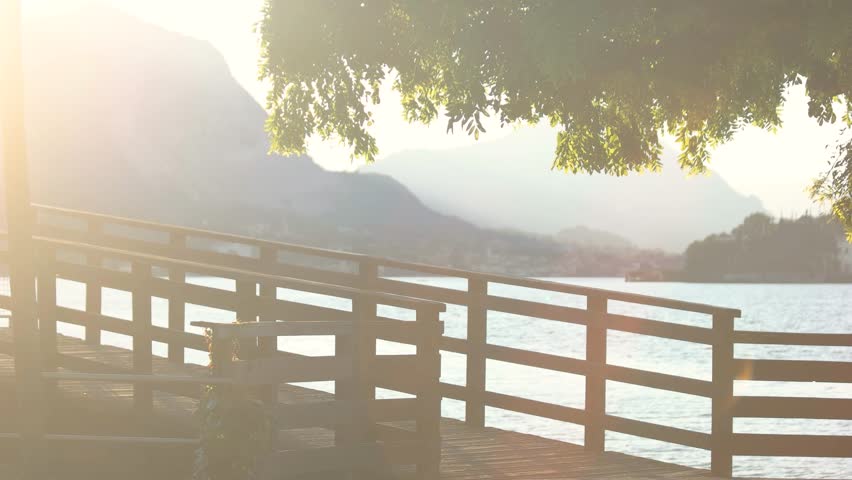 Lake Maggiore, sunny morning. Pier on scenic background.