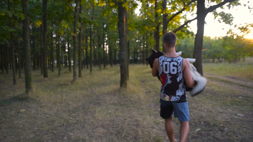 young active male playing with cute siberian husky dog in park