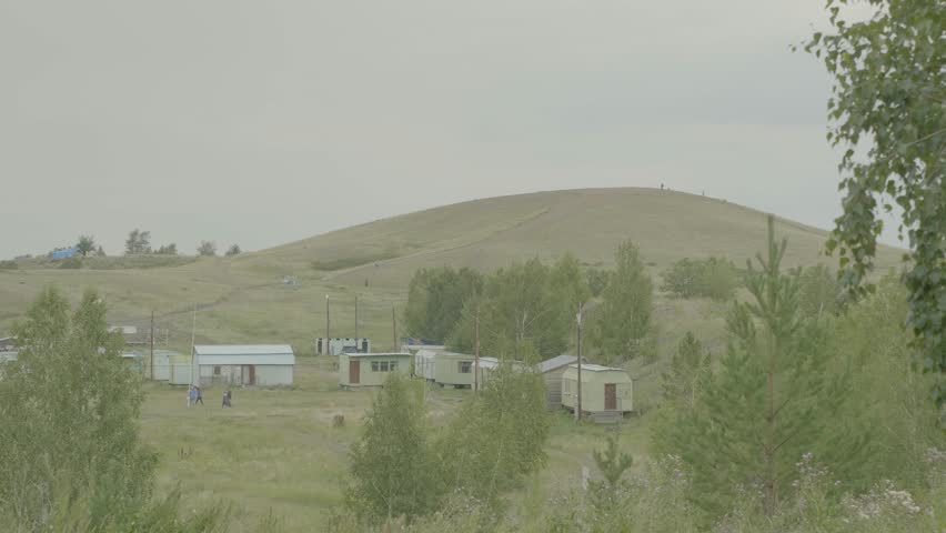 The village is in the mountains and grass in a mountainous area, a small settlement in the highlands