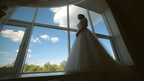 bride in the dress of the big window against the sky