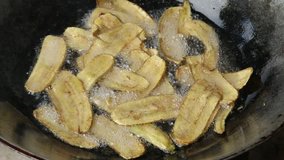 Banana deep frying on hot oil in a iron pan, Thai traditional food.