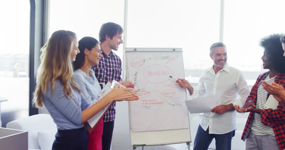 Executives applauding their colleague while giving presentation on flipchart 4k in office Royalty-Free Stock Footage #31287355