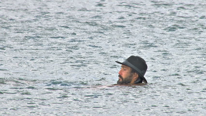 Man in Hat Swimming and Standing in Water
