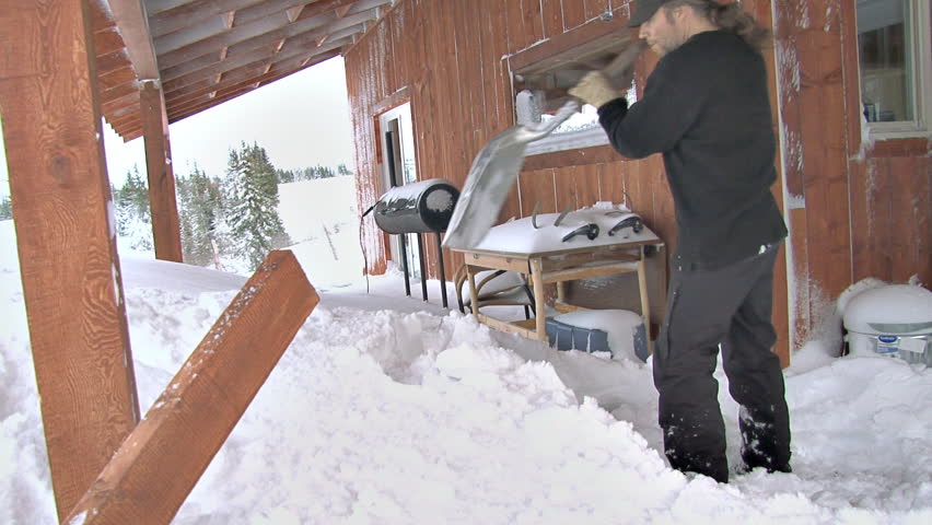 man shoveling the Deck. Heaving snow off deck after a nasty blizzard dumped a