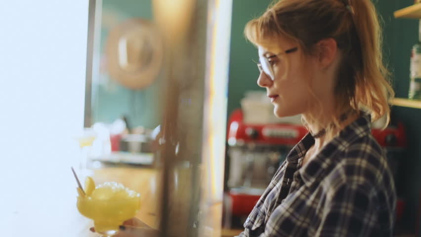Portrait young beautiful caucasian cafe owner waitress standing side view barkeeper holding glass cocktail orange thoughtful smiling looking camera service bar summer barmaid woman stylish worker Royalty-Free Stock Footage #31291990