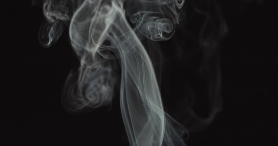 Candle blown out and white smoke rising up on black background
