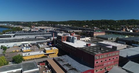 A daytime aerial establishing shot of the various businesses and warehouses along the Ohio River shoreline on Pittsburgh's west end district.  	