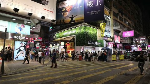 MONG KOK, HONG KONG - SEPTEMBER 23, 2017 :People crossing street at Mong Kok, Hong Kong at night. Mong Kok is area known for shopping, mixture of old and new buildings, with shops and restaurants. VDO