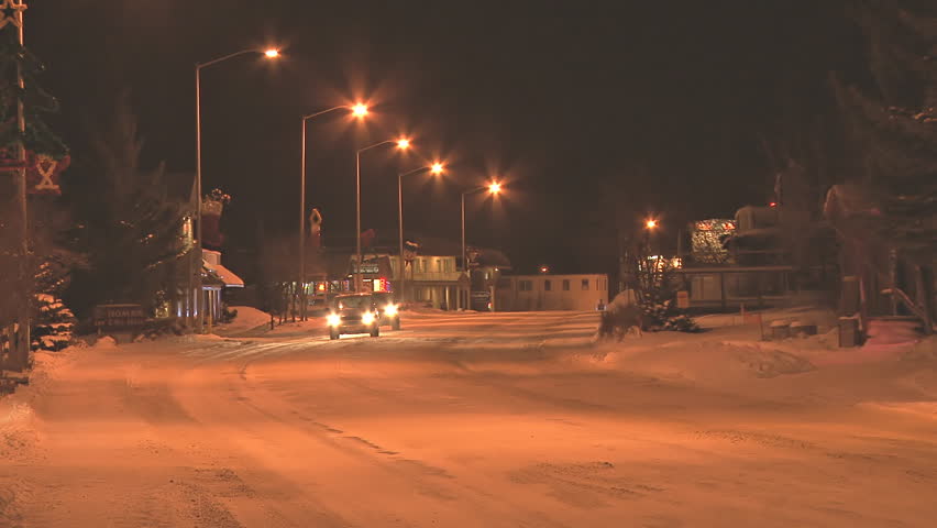 HOMER, AK - CIRCA 2012: Minimal traffic at night in a small town on snow-covered