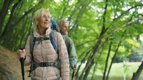 Positive retired woman walking with her husband in the wood