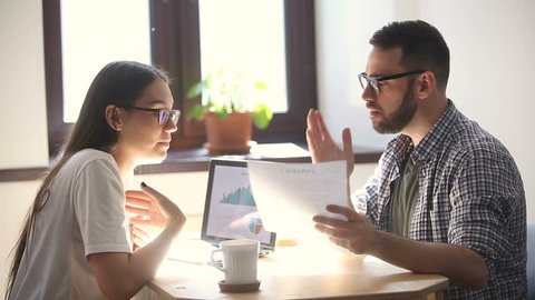 Man and woman arguing disagreeing about bad business contract, colleagues having conflict dispute about document sitting at office desk, partners shouting breaking agreement with unacceptable terms