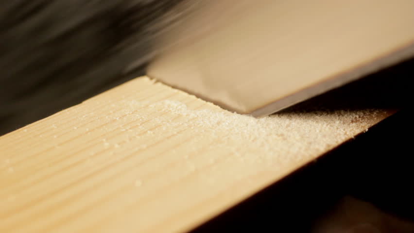 Carpenter sawing wooden plank CU